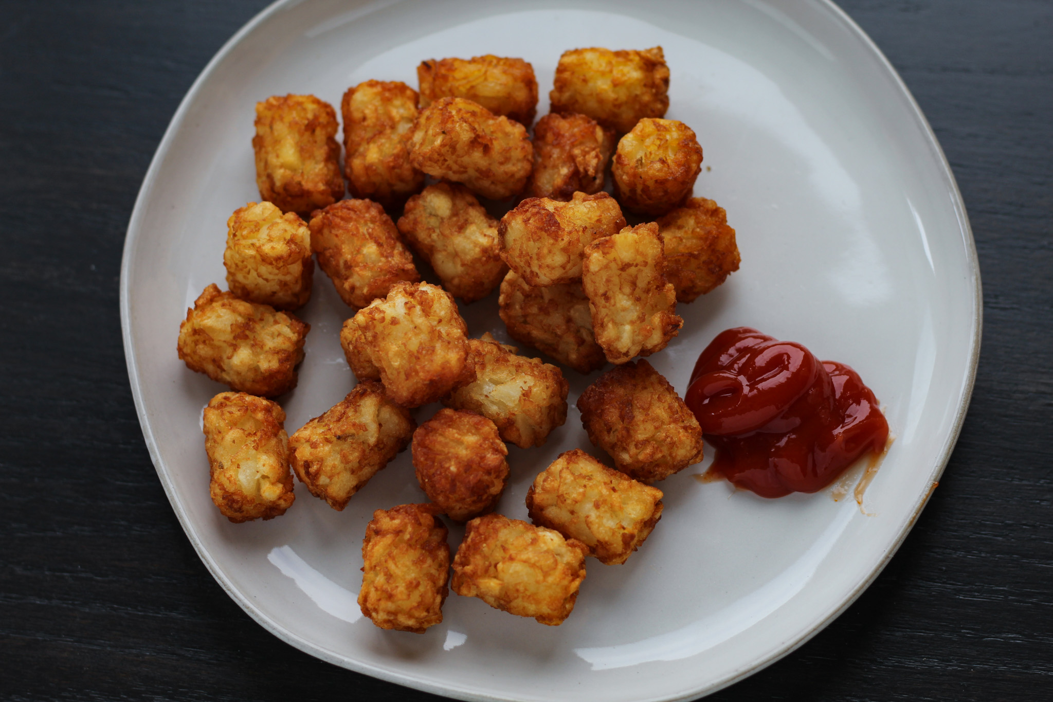 Tater tots on plate with ketchup