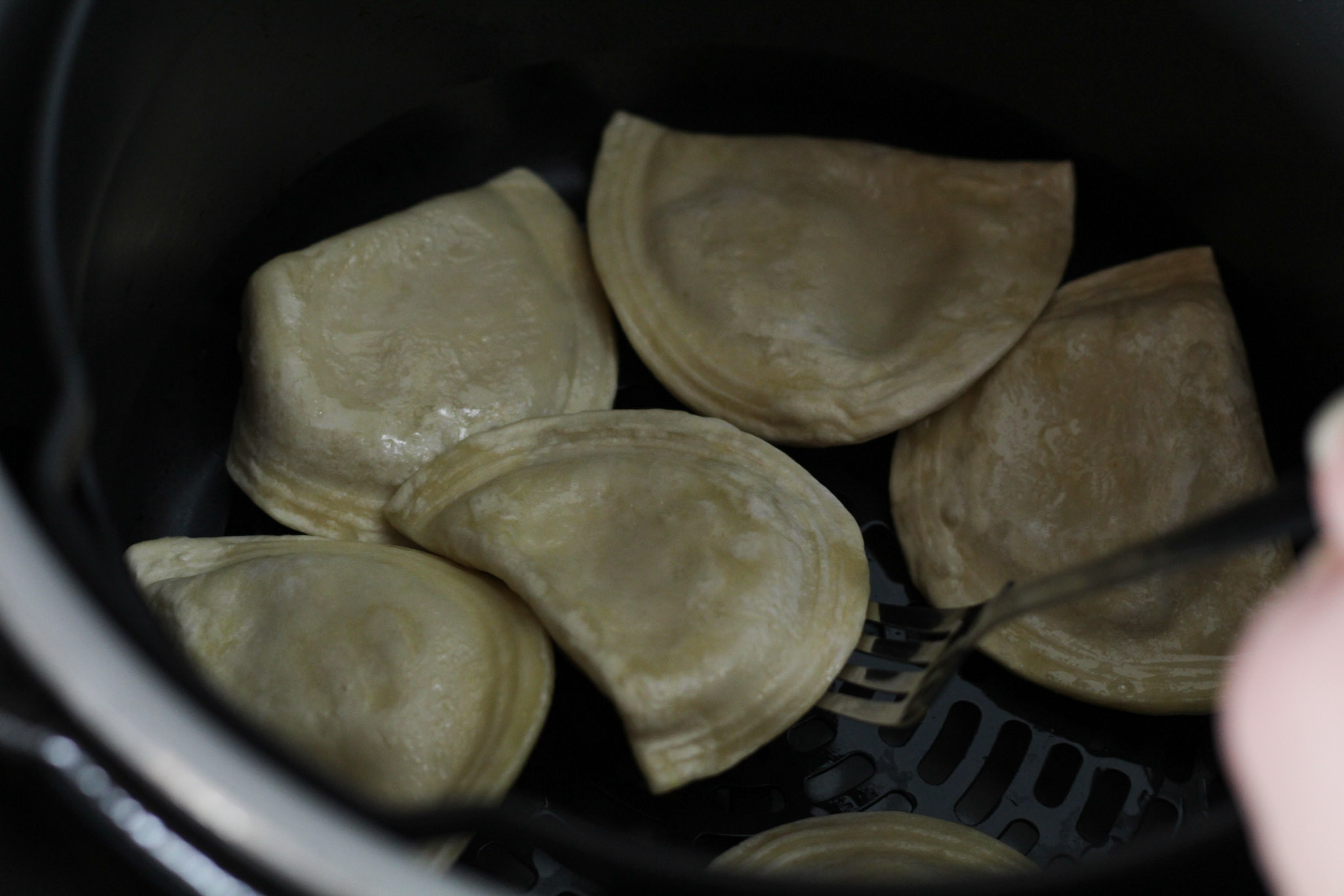 flipped frozen pierogies with a fork after halfway cooking them in an air fryer
